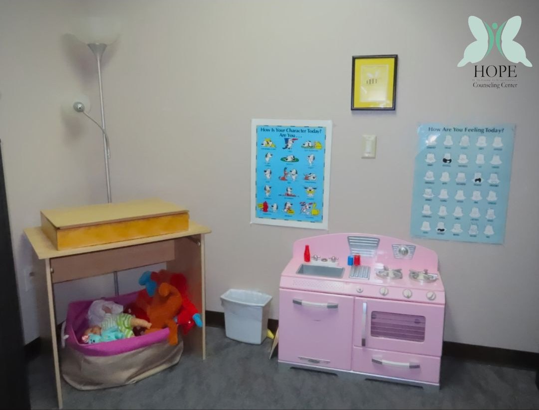 A play kitchen and toy shelves, so younger clients can settle in through play.