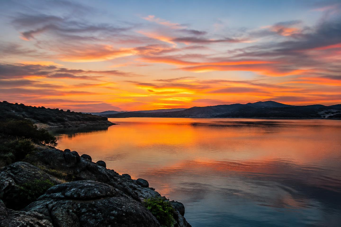 A many-colored sunset reflected across Folsom Lake.